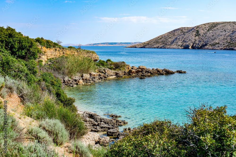 View from a beach during summer, located on a beautiful island of Rab on the Adriatic coast in the heart of Mediterranean sea. Surrounded by the crystal clear turquoise sea and blue sky.