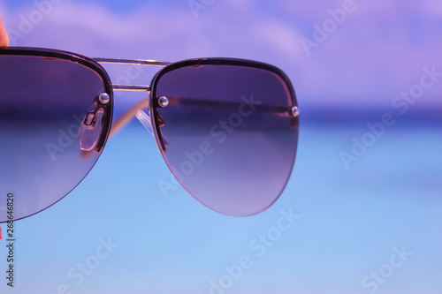Sunglasses on Blue Sea blurred Background.
