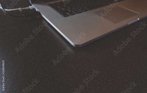 Laptop computer on a back wooden desk, top view copy space in concept