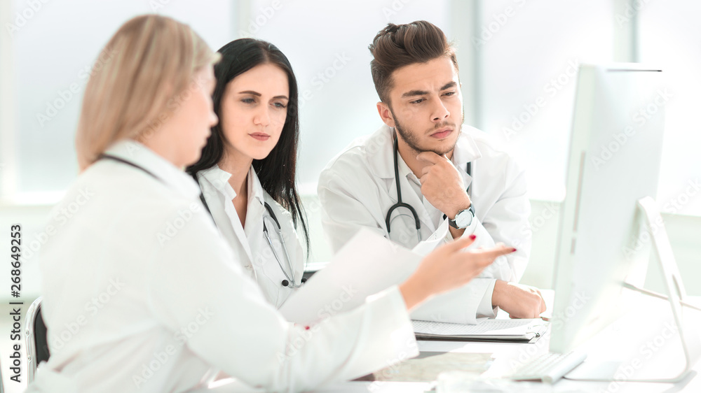 medical professionals are discussing something sitting at the office Desk medical professionals are discussing something sitting at the office Desk