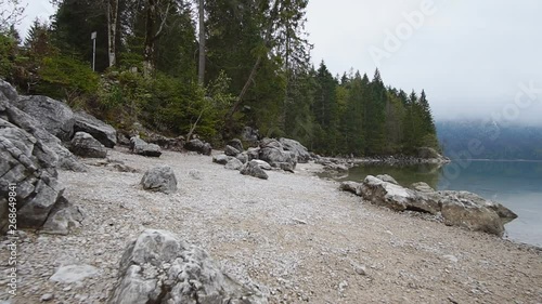 Steadycam shot of a rocky coast of lake in mountains, slow motion photo