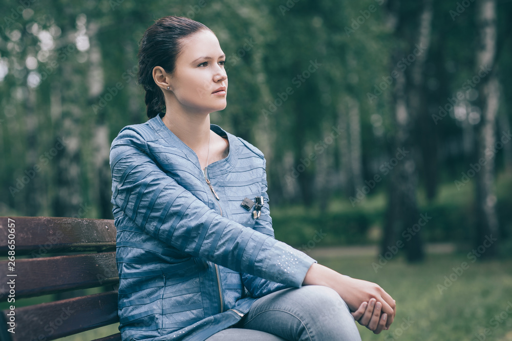fashionable beautiful woman sitting on a Park bench fashionable beautiful woman sitting on a Park bench