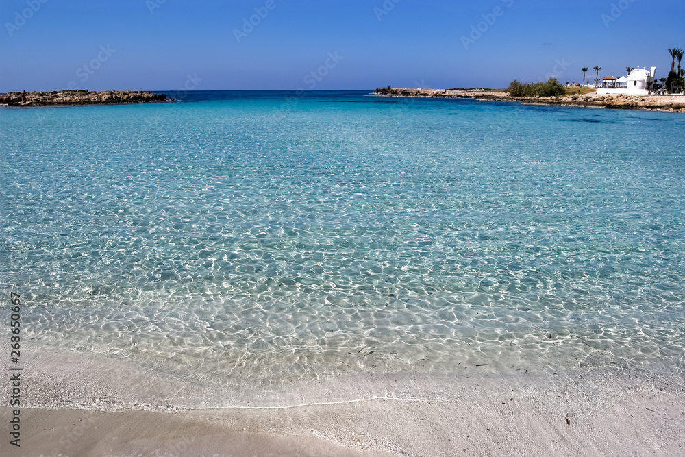 Seascape with white sandy beach and blue transparent sea, Cyprus.