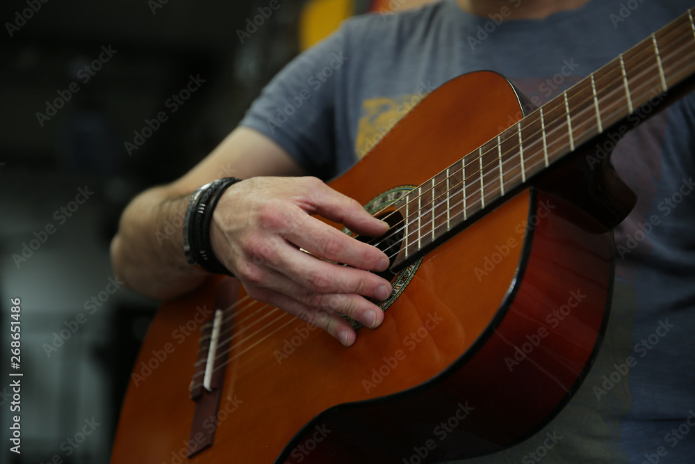 Man playing a classic guitar. Hand picks up the strings on the guitar.