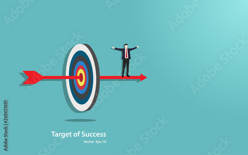 Happy businessman stand on arrow penetrate in the target center of success