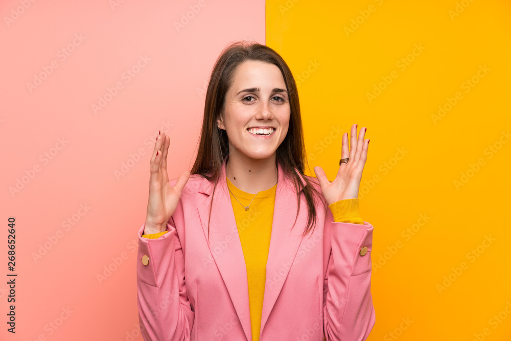 Young woman with pink suit over colorful background laughing Young woman with pink suit over colorful background laughing