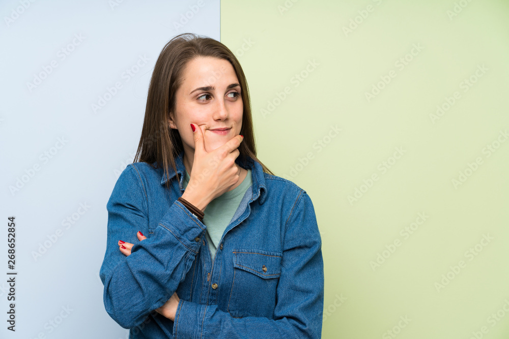 Young woman over colorful background thinking an idea Young woman over colorful background thinking an idea