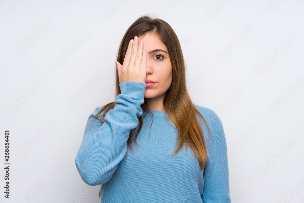 Young girl with blue sweater covering a eye by hand Young girl with blue sweater covering a eye by hand