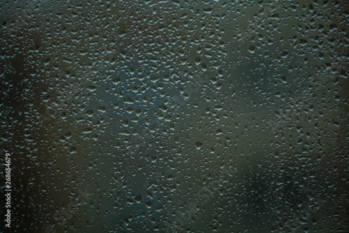 Background or texture. It is a lot of small a rain drops on window glass. Rainy day of spring.