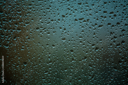 Background or texture. It is a lot of small a rain drops on window glass. Rainy day of spring.