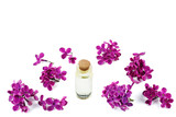 Purple lilac flowers and bottle of oil isolated on white background
