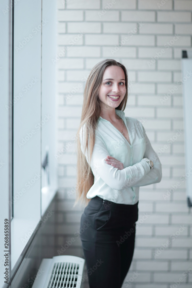 business woman standing near the window in the corridor of the office. business woman standing near the window in the corridor of the office.