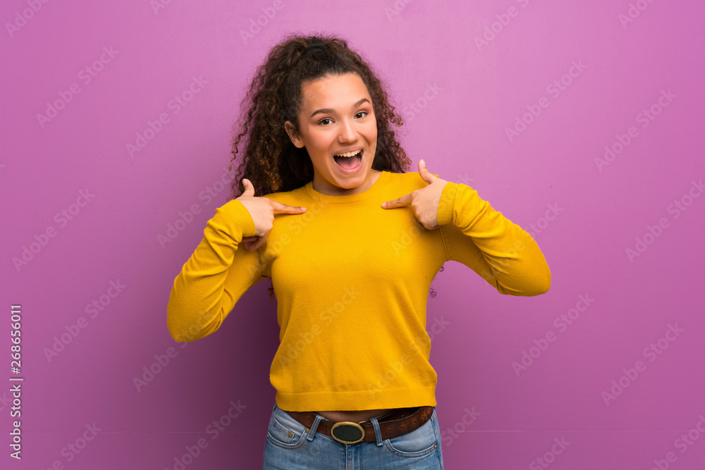 Teenager girl over purple wall with surprise facial expression Teenager girl over purple wall with surprise facial expression