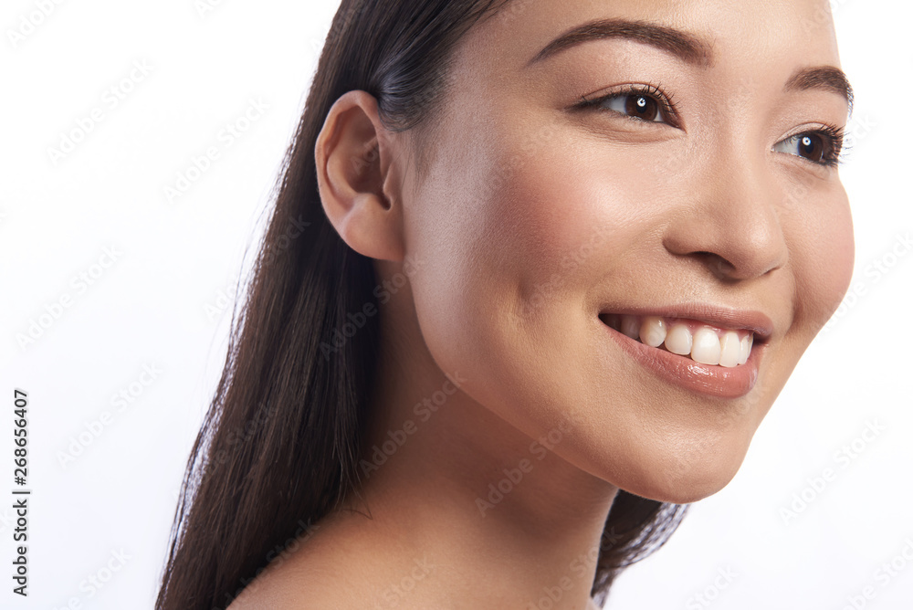 Pretty Asian woman looking happy and smiling with teeth revealed Pretty Asian woman looking happy and smiling with teeth revealed