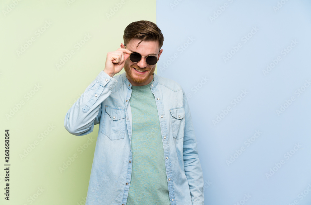 Redhead man over colorful background with glasses and happy Redhead man over colorful background with glasses and happy