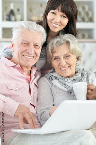 Close-up portrait of happy family with laptop at home