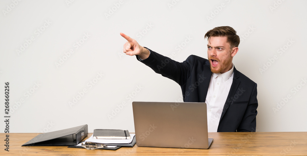 Businessman in a office pointing away Businessman in a office pointing away