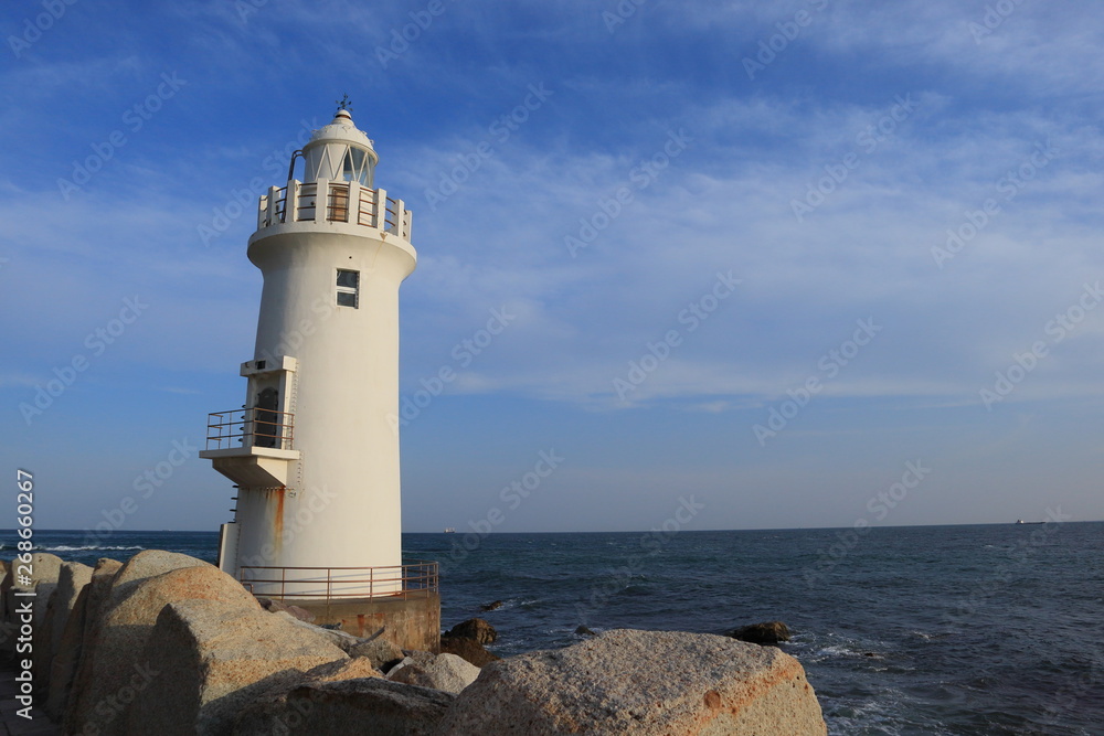 a white lighthouse on an island