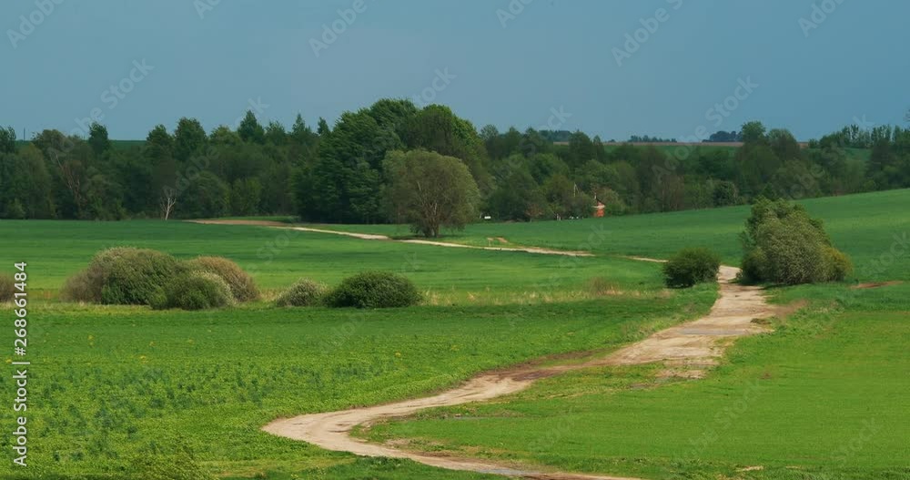 Sandy Winding Countryside Road Path Walkway Lane Through Spring Meadow In Sunny Warm Day. The Air Melts From The Heat In Warm Summer Day Sandy Winding Countryside Road Path Walkway Lane Through Spring Meadow In Sunny Warm Day. The Air Melts From The Heat In Warm Summer Day