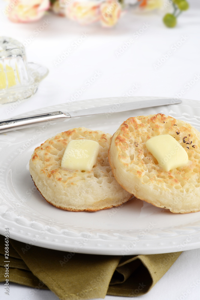 english crumpets with melting butter and a knife