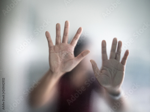 Blurry woman hand behind frosted glass metaphor panic and negative dark emotional