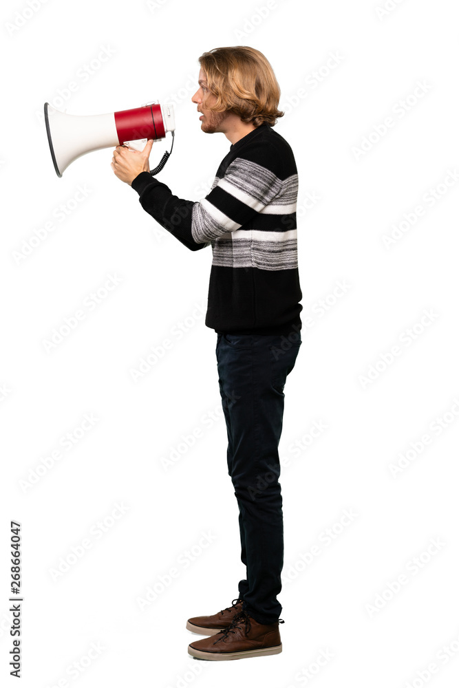 Full-length shot of Blonde man shouting through a megaphone over isolated white background Full-length shot of Blonde man shouting through a megaphone over isolated white background