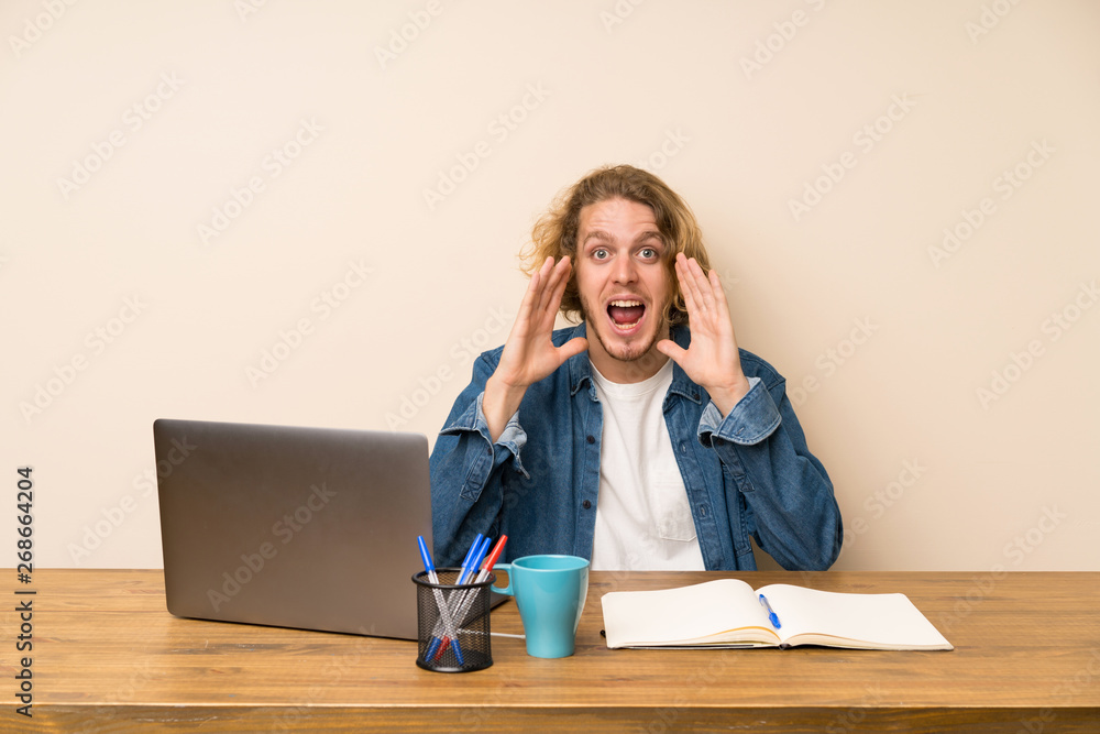 Blonde man with a laptop shouting with mouth wide open Blonde man with a laptop shouting with mouth wide open