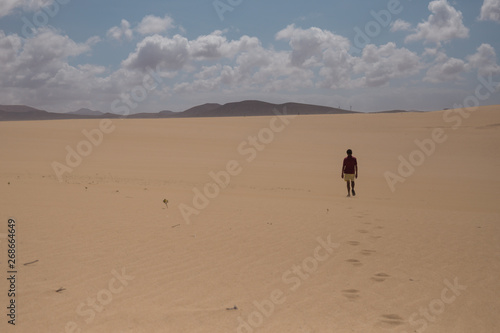 Man walks through sand dunes