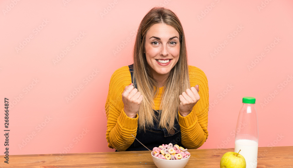 Young woman with bowl of cereals celebrating a victory Young woman with bowl of cereals celebrating a victory