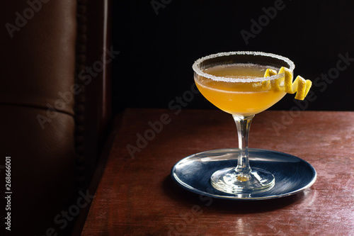 Sidecar Cocktail Served Up with Sugared Rim in Dark Luxurious Bar with Copy Space