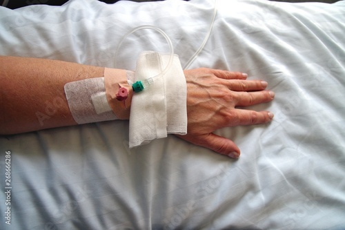 Female patient with infusion drip in hospital. arm of Woman, patient's hand, bottle of infusion in a hospital room during the Coronavirus COVID-19 disease epidemic, corona virus pandemic outbreak. photo