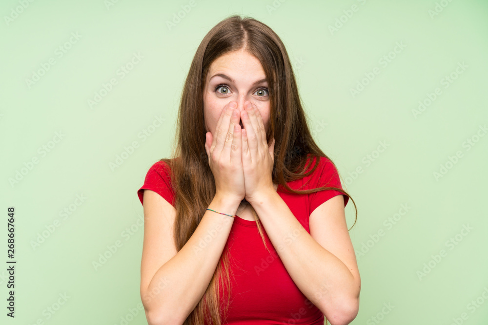 Young woman with long hair over isolated green wall with surprise facial expression Young woman with long hair over isolated green wall with surprise facial expression