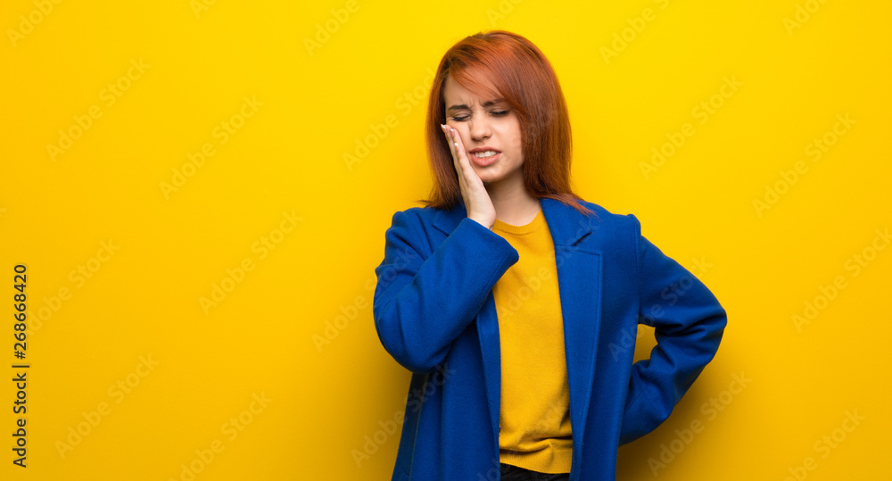 Young redhead woman with trench coat with toothache Young redhead woman with trench coat with toothache