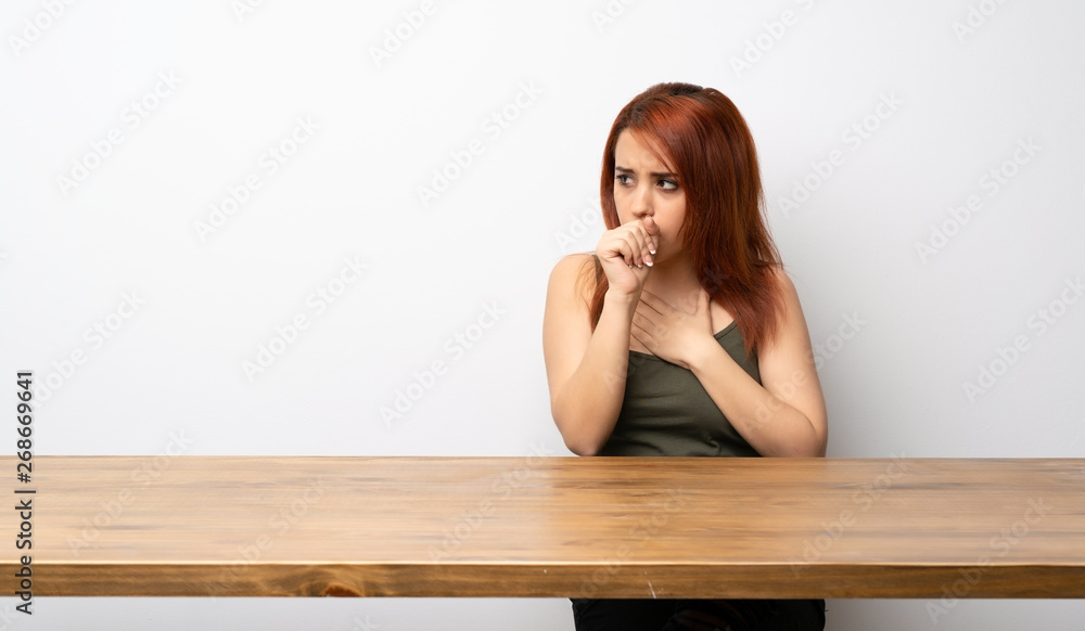 Young redhead woman at desk is suffering with cough and feeling bad Young redhead woman at desk is suffering with cough and feeling bad