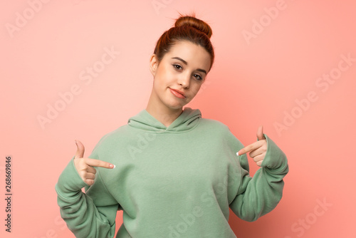 Young redhead woman with sweatshirt proud and self-satisfied photo