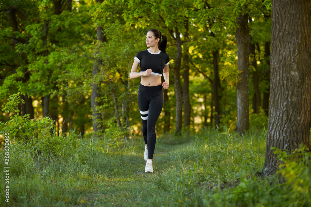 Sexy, sporty girl with a beautiful figure wearing a sports brassiere and leggings, doing sport exercises, outdoor running Sexy, sporty girl with a beautiful figure wearing a sports brassiere and leggings, doing sport exercises, outdoor running