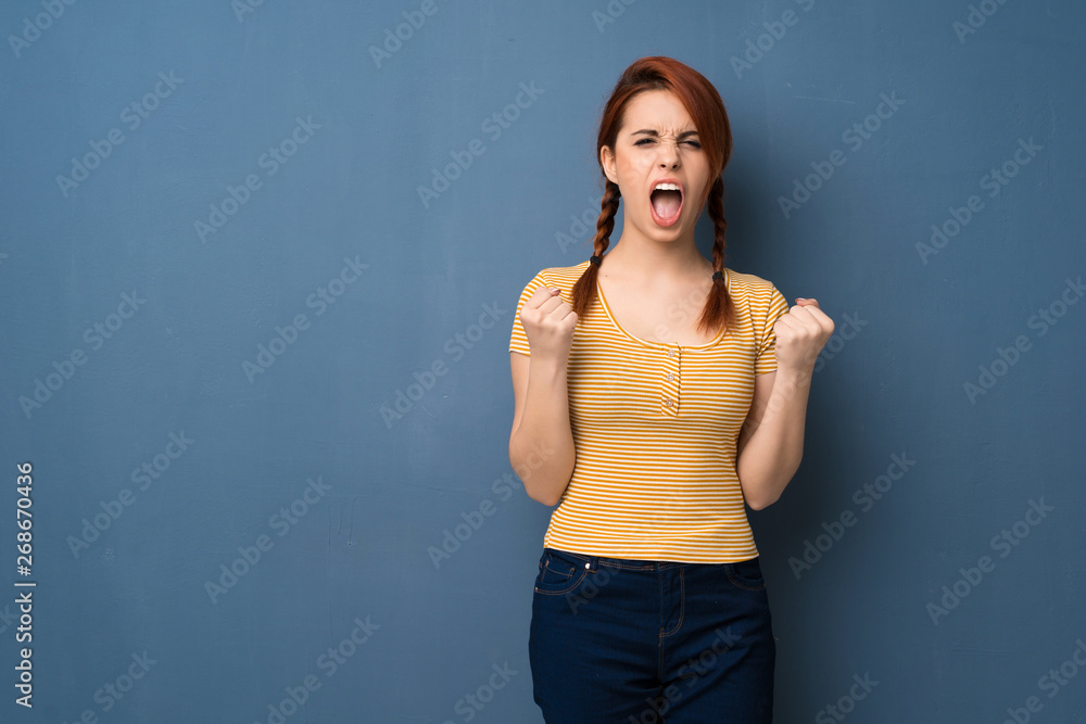 Fototapeta premium Young redhead woman over blue background frustrated by a bad situation