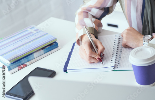 Top view of business woman hands making notes with silver pen in office background. Business finance savings loan and credit concept.