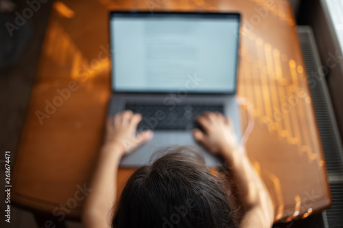 Children hands typing on keyboard of laptop