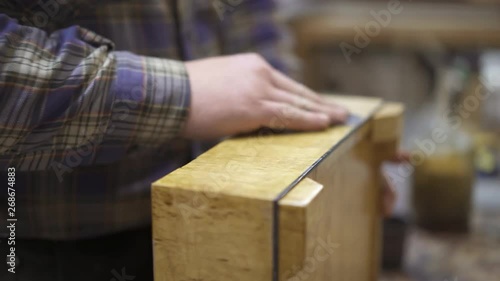 Man cleaning and polishing a light wooden surface of stand with a rag. Handheld shot of male hand polishing circular motions an old light wooden box
