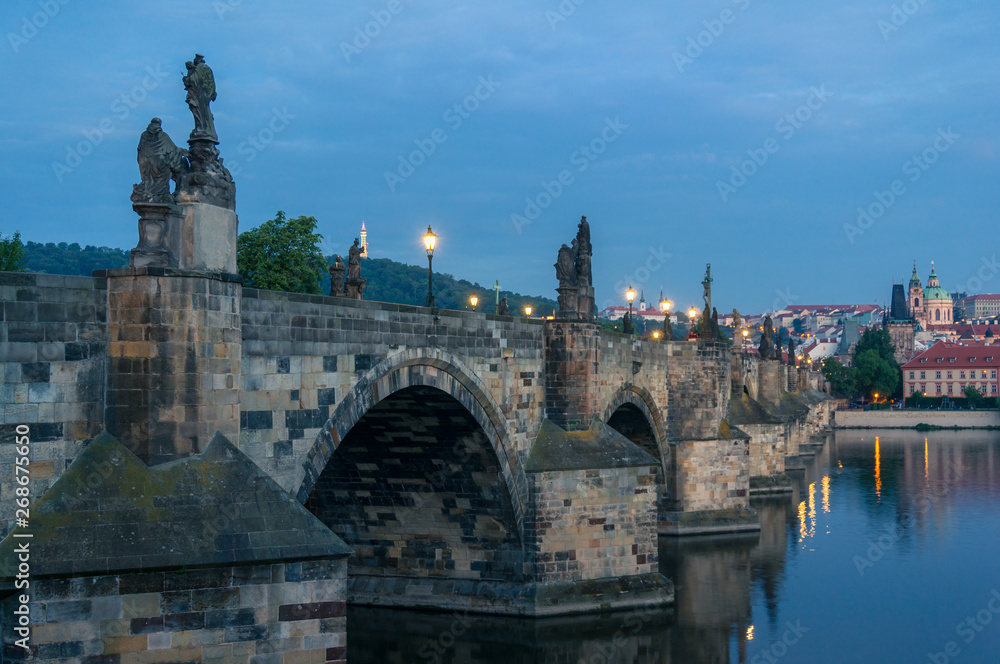 Charles bridge with stone sculptures and street lights