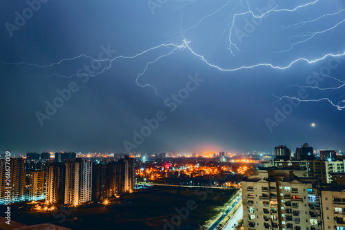 Multiple lighting bolts thunder during a storm with a dramatic blue sky in noida, delhi India - Image