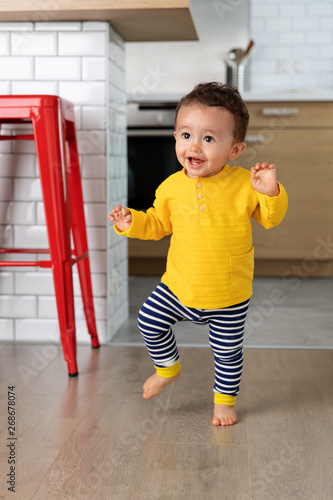 Toddler making first steps at home
