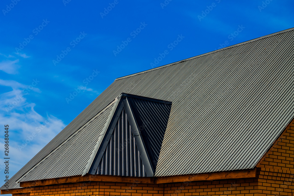detailed roofing on a brick building under a clear blue sky; there is a lot of space for text diagonally; dark version detailed roofing on a brick building under a clear blue sky; there is a lot of space for text diagonally; dark version
