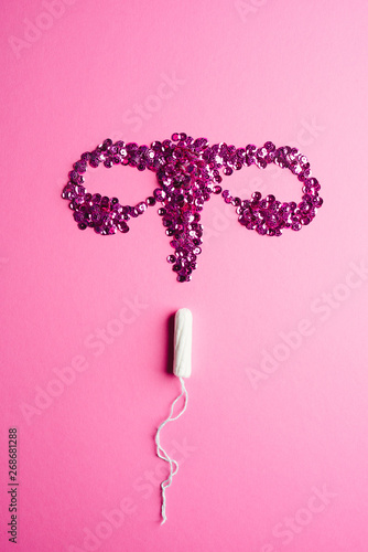 Tampon and ovary on pink background photo