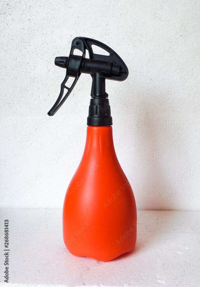 Orange sprayed bottle close up on the white background. Isolated. Orange sprayed bottle close up on the white background. Isolated.