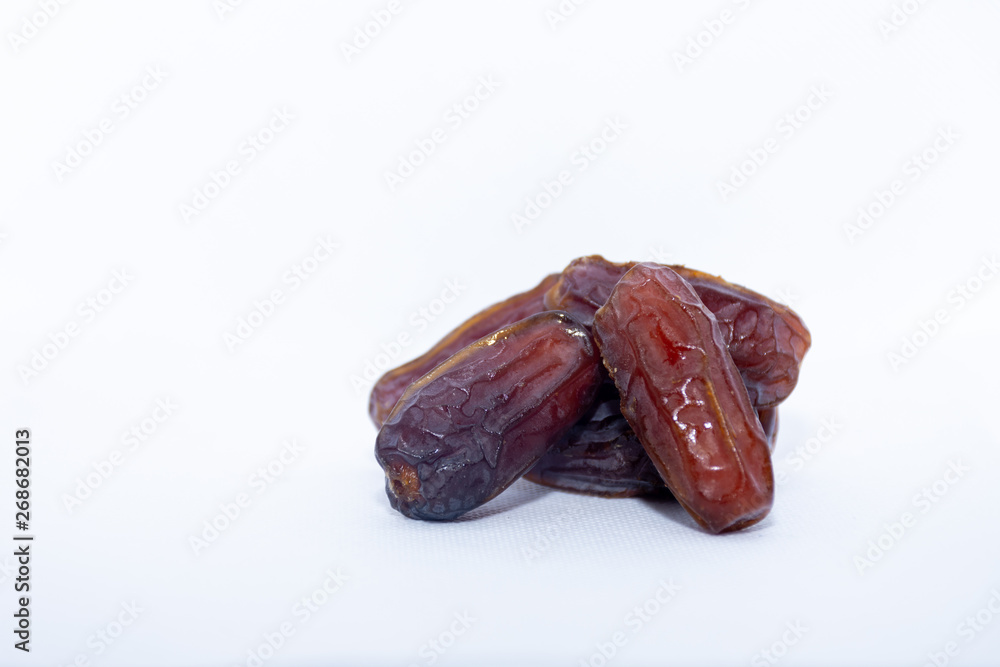 A group of medjool dates bottom right from Saudi Arabia on an isolated white background for Ramadan. A group of medjool dates bottom right from Saudi Arabia on an isolated white background for Ramadan.
