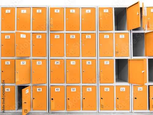 .many orange cabinets, safe deposit boxes with keys for storing things in the supermarket and store. Safes for buyers