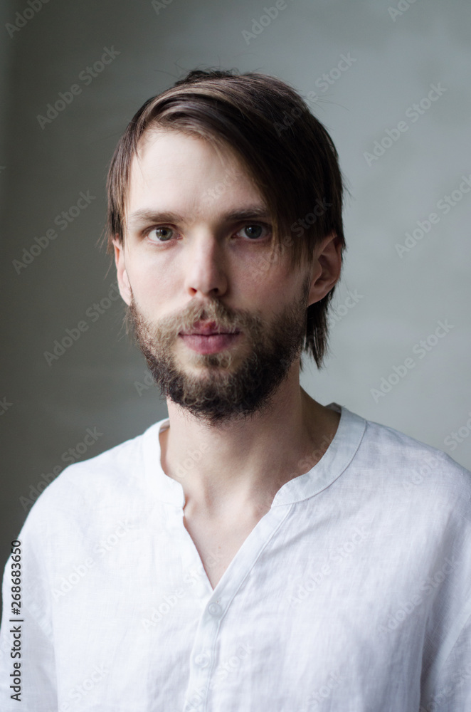 Portrait of a young man in a white shirt with a beard Portrait of a young man in a white shirt with a beard