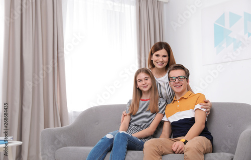 Happy mother with her teenager daughter and son at home